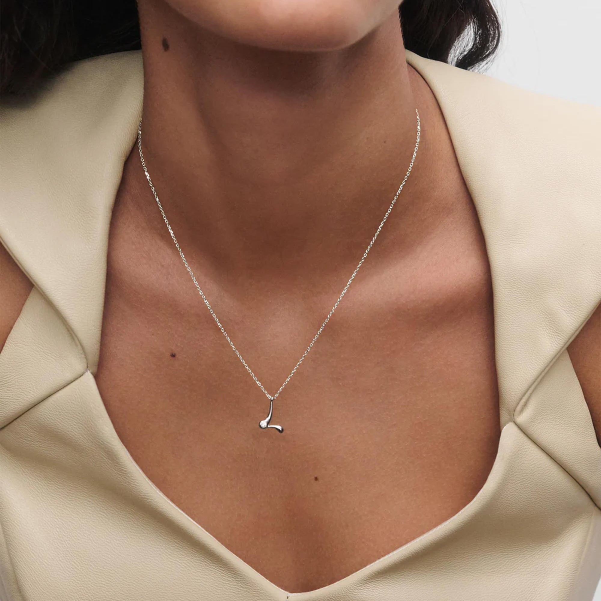 model wearing PDPAOLA sterling silver initial L necklace with round cubic zirconia