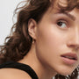 model wearing PDPALOA 18ct gold plated sterling silver hoop earrings with round cz charm drop