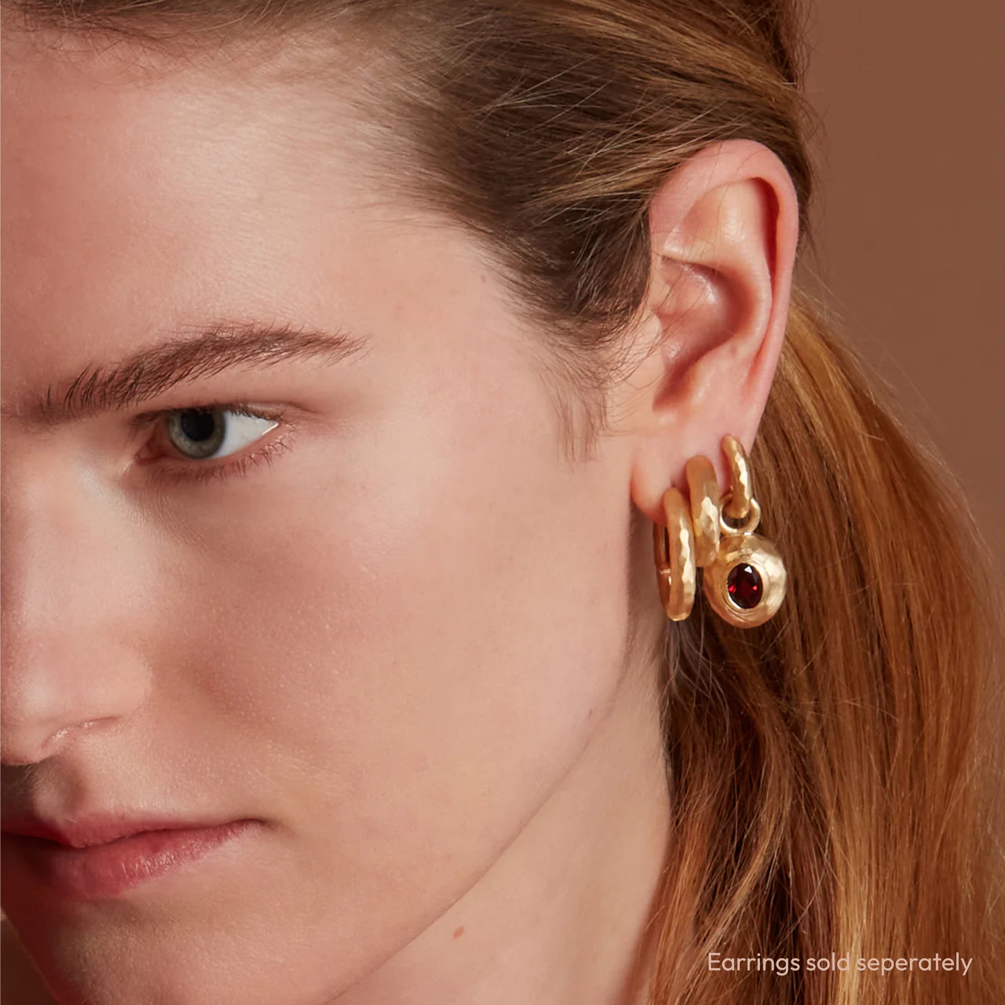 Model Wearing Eloise 18ct Gold Plated Sterling Silver Small Oval Garnet Milestone Sasso Charm on Hoop Earring Stacked With Two Other Hoop Earrings
