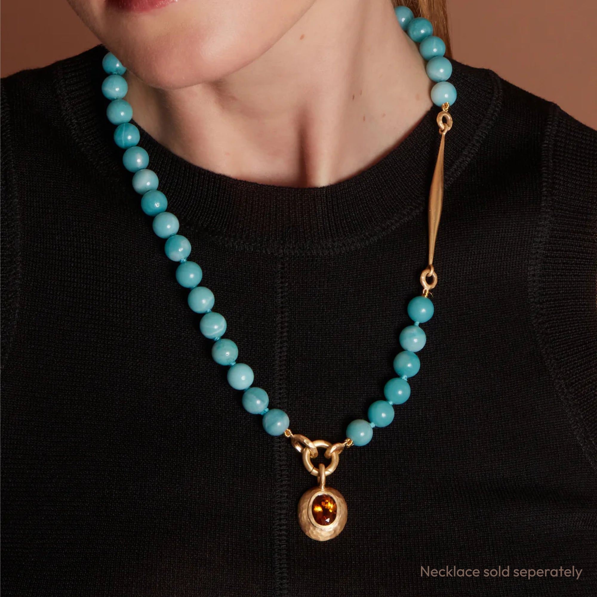 Eloise Gold Plated Sterling Silver Small oval Milestone Sasso charm set with a faceted oval Orange Madeira Quartz featured on a model wearing a necklace with the charm pendant