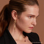 Model Wearing Eloise Gold Plated Sterling Silver Large Spindle Charm on Hoop Earring and Ellipse Necklace