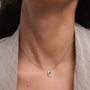 Model wearing a PDPAOLA sterling silver initial R necklace with cz