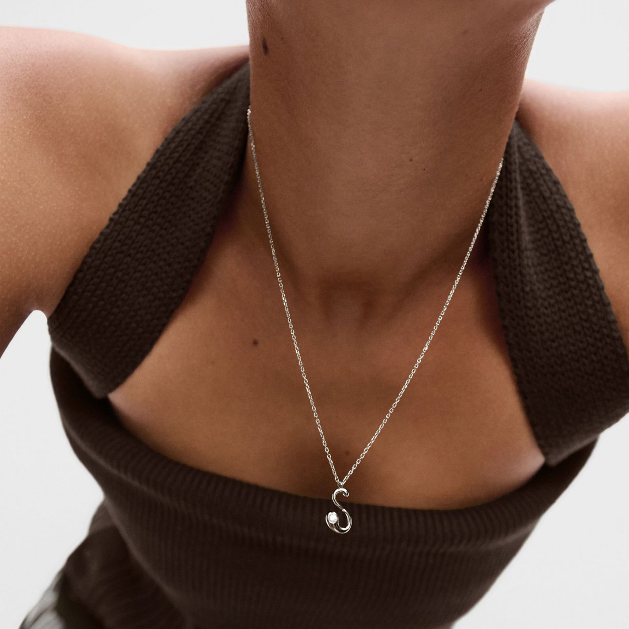 Model wearing a PDPAOLA sterling silver initial S necklace with cz