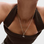 Model wearing a PDPAOLA sterling silver initial S necklace with cz
